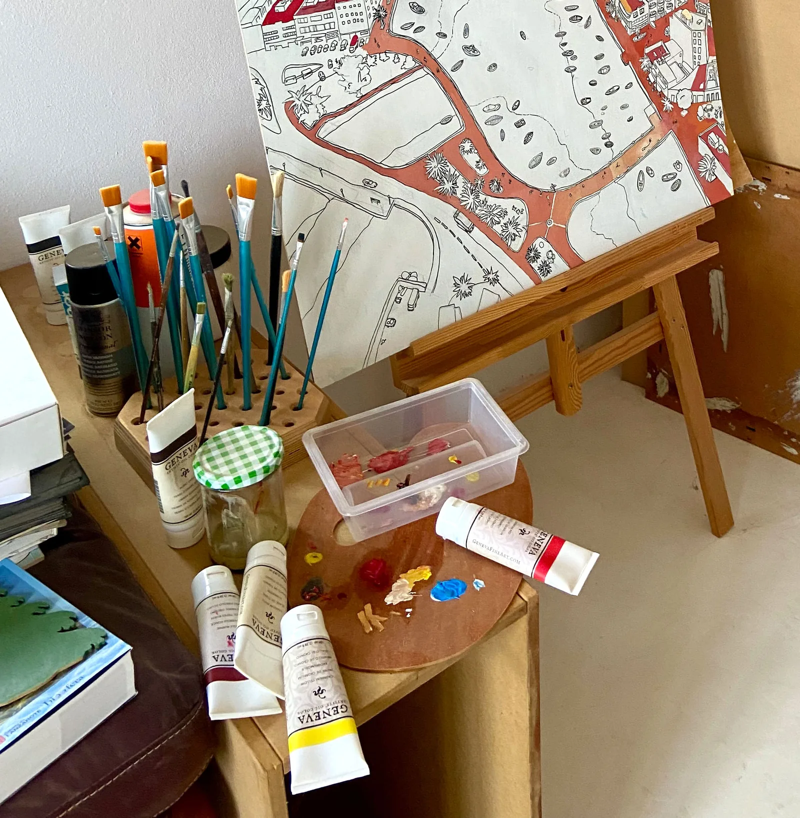 Pinsel, Farben und eine Zeichnung auf einer Staffelei in Pekkas Atelier